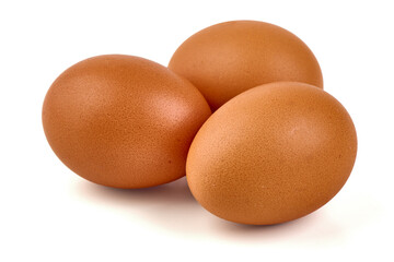 Three brown chicken eggs with textured shells are clustered together, casting a soft shadow, isolated on white background