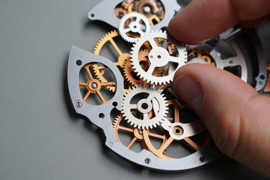 Assembling Complex Watch Mechanism Fine Art of Precise Engineering Hand Placing Gear on Watch Movement Showcasing Intricate Details and Craftsmanship