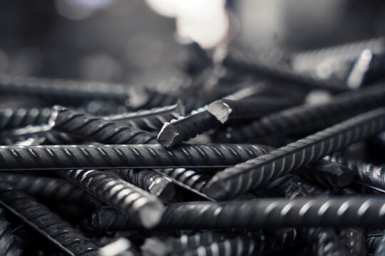 Rough, textured rebar fills frame with a focus on a single bar's end.