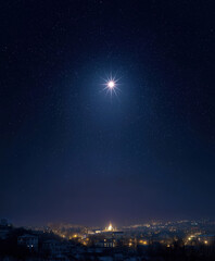 Starry night sky featuring the bright Star of Bethlehem shining over a cityscape, capturing the beauty of a clear evening