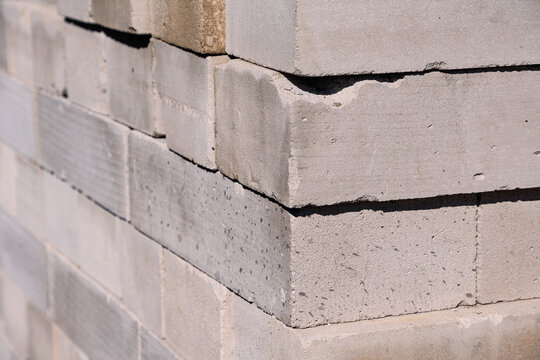 Stacked gray cinder blocks or bricks with rough concrete texture, forming a pattern ideal for building, construction, and background themes