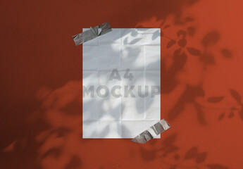 A4 Paper Mockup With Multiple Folds Taped On The Wall