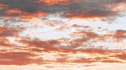 Fototapeta premium Striking cloudscape where light brushes the horizon. Hues of orange and gray dance across the sky, creating an ethereal scene during the golden hour. Nature's masterpiece unfolds.