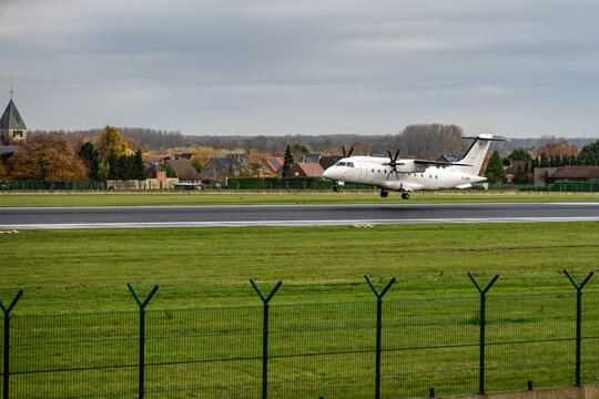 Turboprop aircraft landing by Brussels Airport control tower