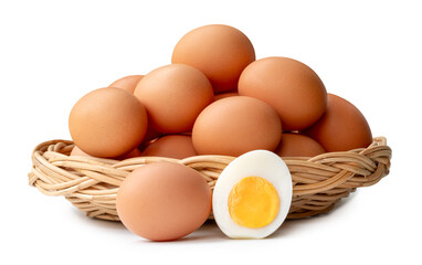 Many raw brown chicken eggs with boiled eggs and egg yolk in a half in stack in wicker basket isolated on white background with clipping path