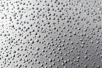 A silver, metallic surface covered with tiny droplets of water.