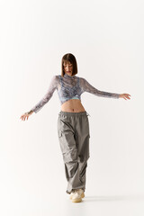 Stylish young woman showcases modern fashion in a minimalist studio setting