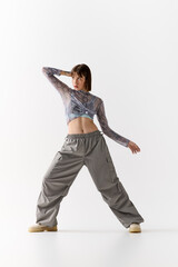 Naklejka premium Stylish young woman poses confidently in modern Fashion against a minimalistic backdrop