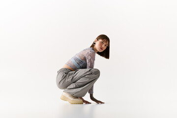 Stylish young woman poses creatively in modern attire for an artistic fashion display