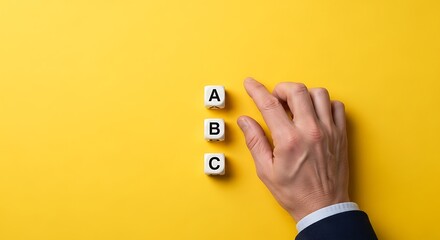 Hand pointing at letter a on dice, representing choice, decision, or selection against a yellow background