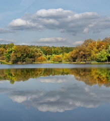 Russia. Moscow Pokrovskoe-Streshnevo Park. Autumn view of the lake shore with yellow-red willows and maples in the city park.
