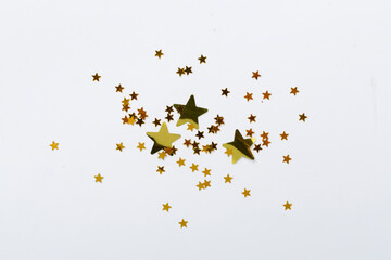 Golden star shape confetti on color background, top view