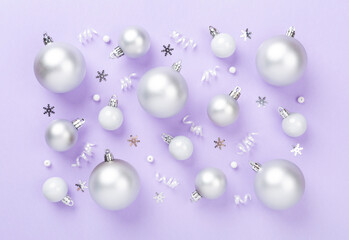Grey Christmas balls with decor on color background, top view