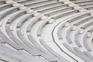 Zbliżenie na betonową strukturę siedzisk amfiteatru ukazujące powtarzalny rytm geometrycznych form i surową estetykę architektury. Kompozycja podkreśla teksturę, linię i minimalistyczny charakter prze
