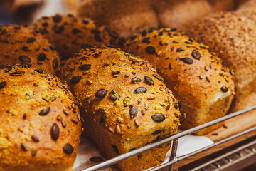 Freshly baked bread with raisins on a wooden stand in the bakery taken off the shelf in the supermarket.
