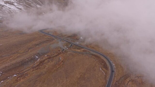 Fall view of Stelvio switchbacks and fog, Italian Alps from air.