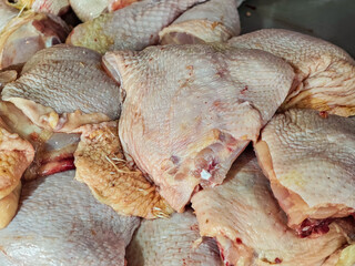 A close-up shot captures raw chicken thighs, showcasing their natural texture and color variations. This image presents a versatile culinary ingredient for various cooking preparations and purposes.