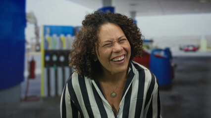 Woman waves hands near petrol station forecourt with visible fuel pumps and cars under daylight on street  pure joy. © Krakenimages.com