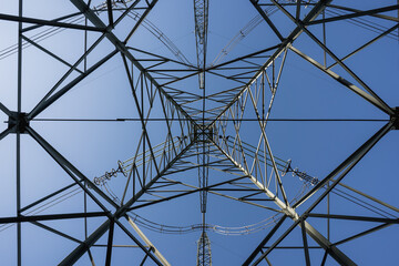 Fototapeta premium High-voltage power line towers with geometric steel structures