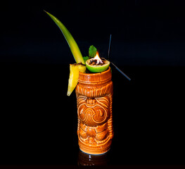 Dramatic Flaming Tiki Cocktail in Ceramic Mug with Pineapple Garnish on Black Background