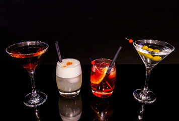Spectacular Collection of Four Classic and Contemporary Cocktails on Reflective Black Bar