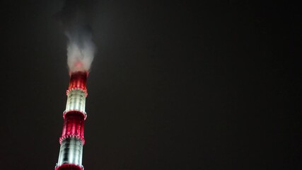 closeup lit chimney stack with plume, colored rings of light and dense vapor rising into black sky, tight vertical crop reveals masonry texture and luminescent bands; ideal for industrial detail, - Powered by Adobe