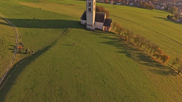 Majestic San Valentino church and peaks seen from drone, Italy.