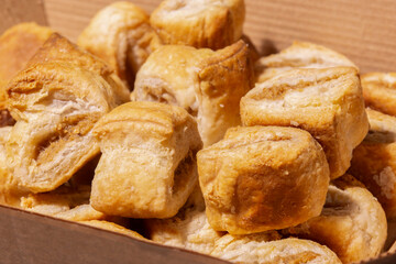 Party cocktail sausage rolls in a cardboard takeaway tray. Sustainable biodegradable plastic free recycling packaging concept