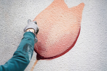 Painting graffiti on the wall. Close up. 