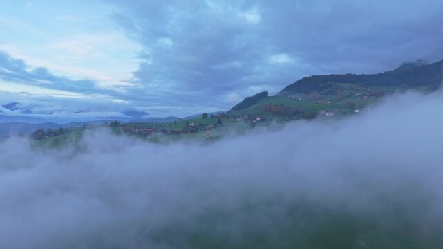 Aerial view of St. Valentin church in Seis, Dolomites with low clouds.