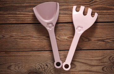 Shovel and rake for sandbox on wooden background