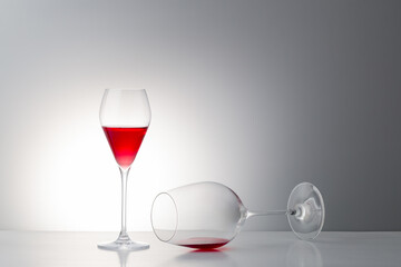 lying down red wine glass with some of red,