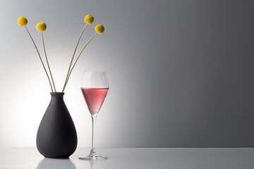 red wine with dried floweron bright background.