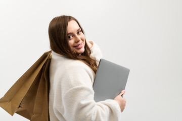 Cozy plus size woman in knitted sweater poses with bags in bright studio