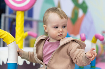 Little cute baby plays in a children's entertainment center