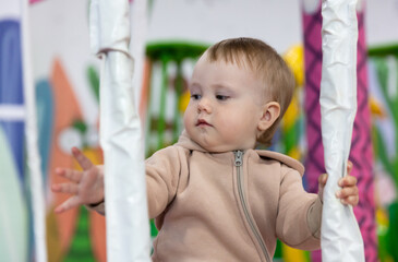 Little cute baby plays in a children's entertainment center