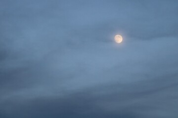 Full Moon Shines Through Ethereal Blue Clouds