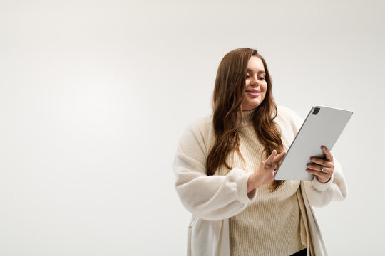 Cozy moments in winter warmth with a young plus size woman enjoying digital content