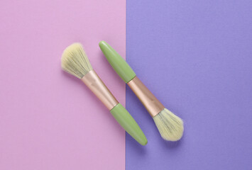 Premium makeup brushes on purple pink background. Beauty concept