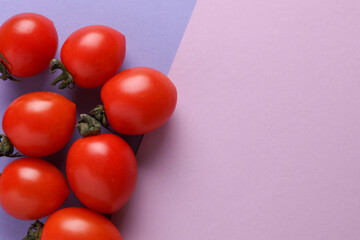 Ripe cherry tomatoes on pink purple background. Top view