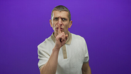 Man gesturing silence with finger on lips against purple background, creating a calm and secluded...