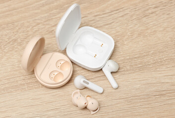 Two pair of Modern Wireless Bluetooth Vacuum Earbuds with Charging Cases on table