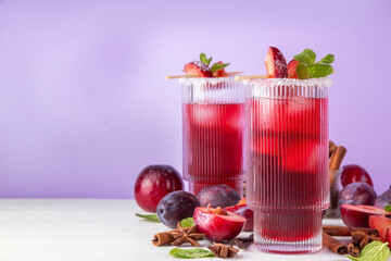 Sugar plum autumn winter sweet tasty drink. Alcohol or non-alcohol cocktail, mocktail with plum syrup, hard liqueur, spices, cinnamon and mint, copy space