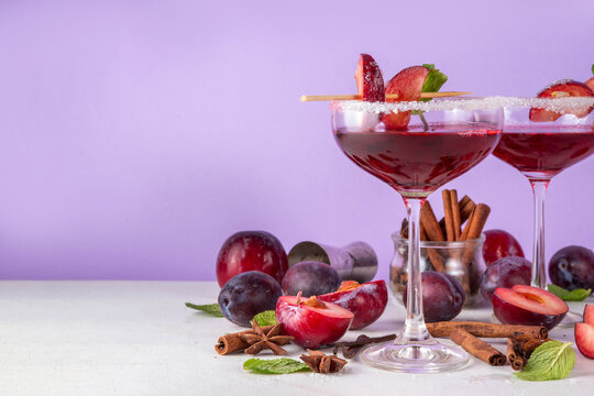 Sugar plum autumn winter sweet tasty drink. Alcohol or non-alcohol cocktail, mocktail with plum syrup, hard liqueur, spices, cinnamon and mint, copy space