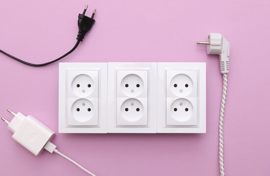 Electrical sockets and electrical plugs on a purple background