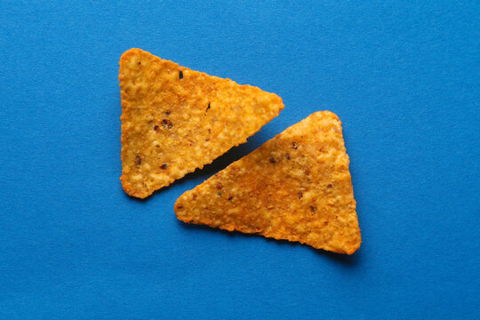 Triangular appetizing corn tortilla chips slices on blue background