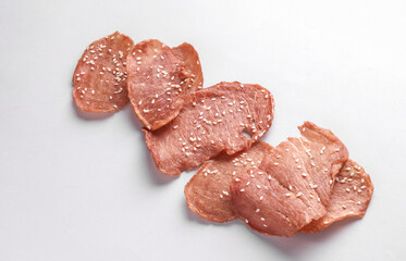 Meat chips with sesame seeds on a white background