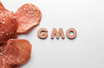 Meat chips and word gmo on white background. Bioengineering. Genetically modified products