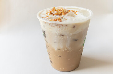 Iced coffee latte with creamy cold foam and caramel crumble. Close up view of Salted caramel milkshake with coffee