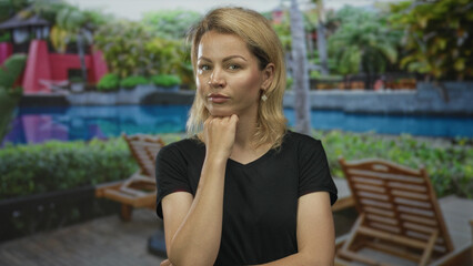 Woman with hand on chin in building; quiet contemplation.